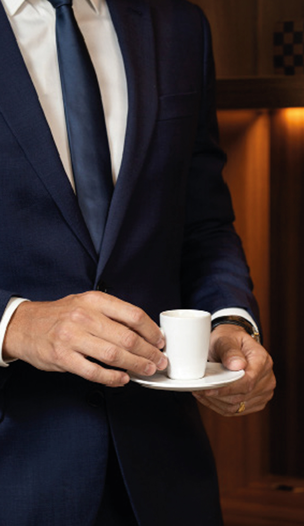 Profissional de terno segurando uma xícara de café